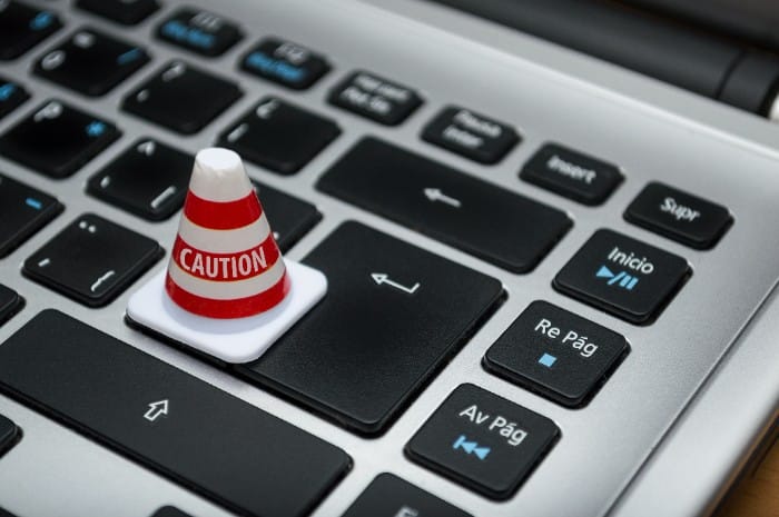 Mini caution cone on a keyboard key symbolizing formatting mistakes in a statement of purpose for grad school