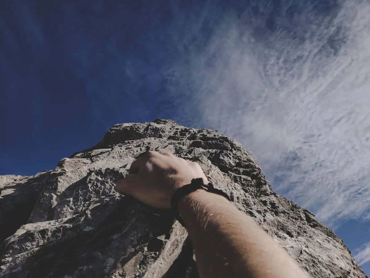 Climbing a steep rock face representing the challenge and perseverance required to get a PhD
