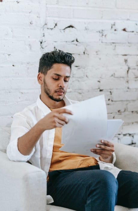 Male MBA reapplicant sorting out his resume before reapplying to business school.