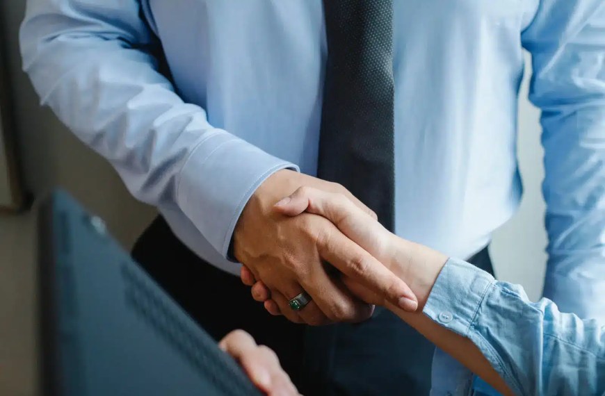 two men shaking hands after scholarship negotiation