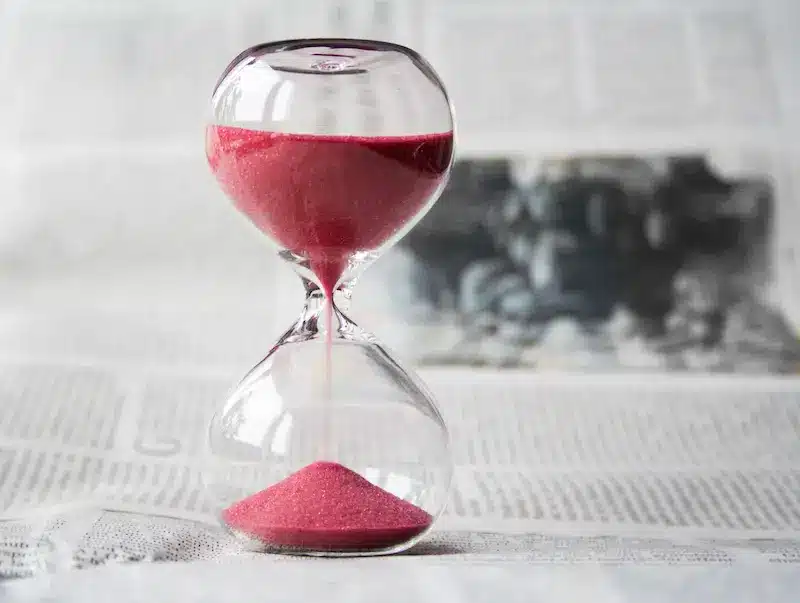 red sand through the hourglass on a paper
