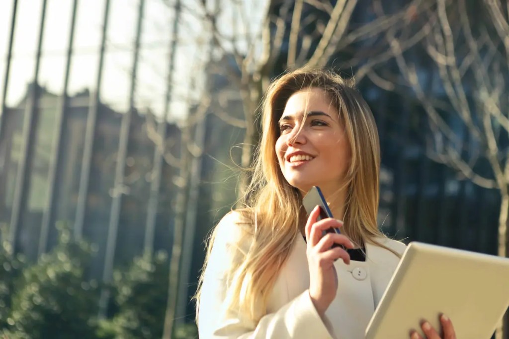 female mba student holding a book in front of building