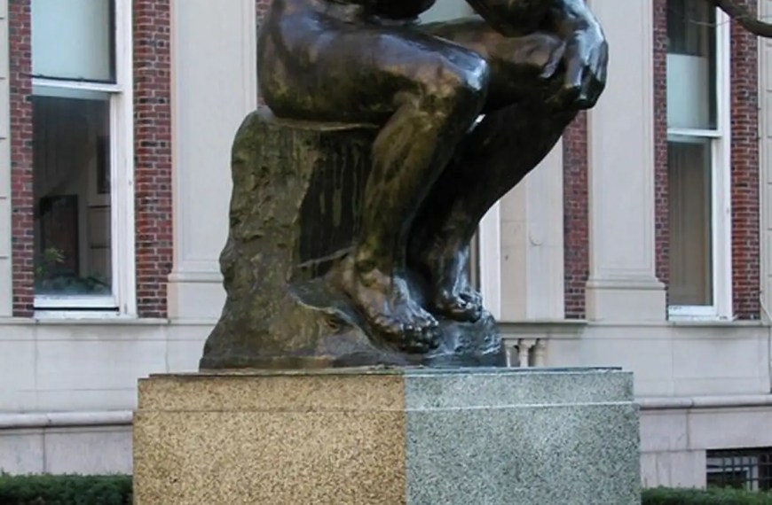 odin’s The Thinker sculpture on a pedestal in front of a university building