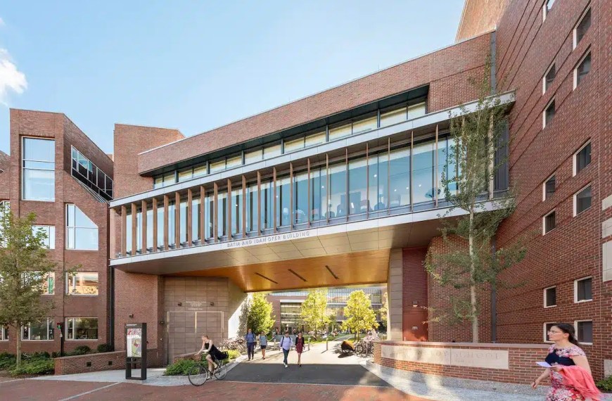 Harvard MPP Students walking through the entrance of Harvard Kennedy School campus building