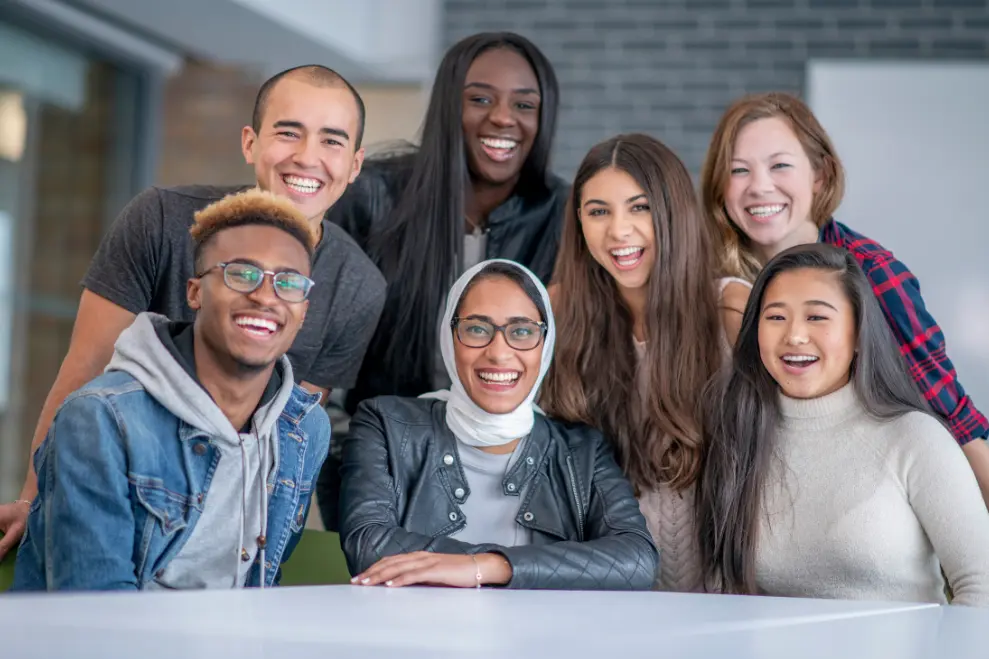 A diverse group of graduate students smiling on campus, representing applicants to top social work programs 2025