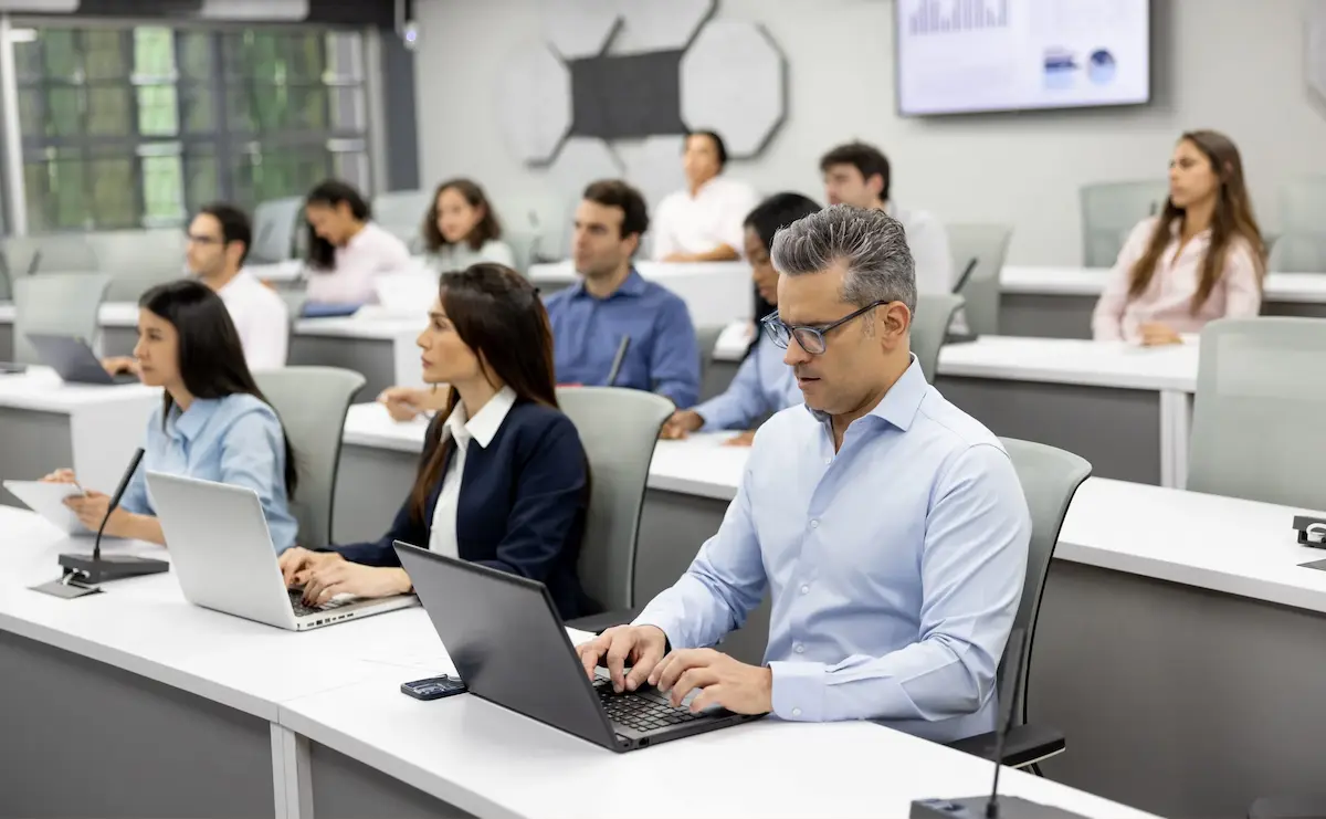 Senior business professionals in a leadership-training classroom for Executive MBA vs MBA comparison