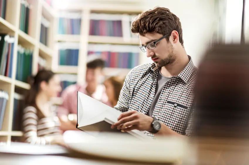 Male PhD applicant without publications reviewing research materials and preparing a doctoral application